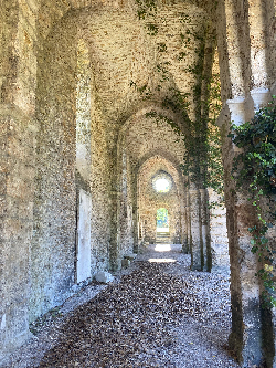 Couloir voûté d’un monastère ancien menant vers la lumière, évoquant le chemin intérieur du lien de flammes jumelles